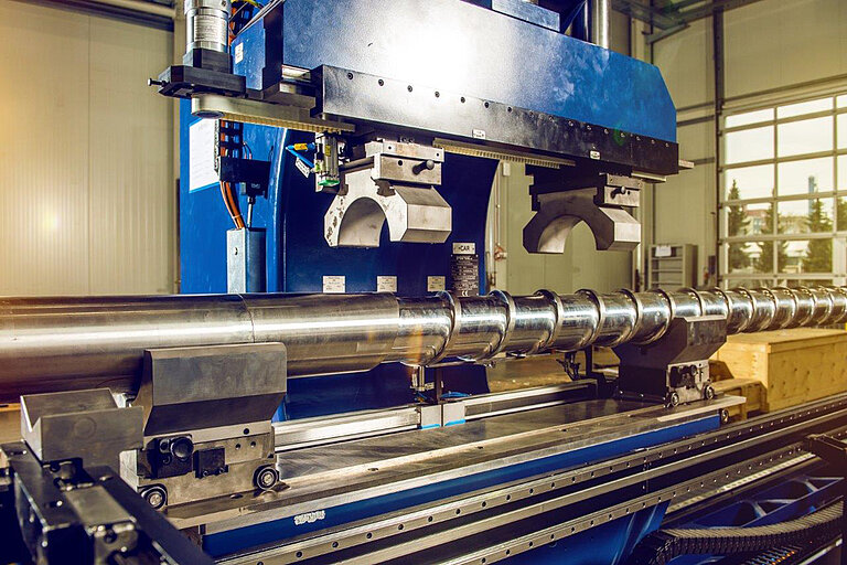 Foto: Gesco: Eine grosse blaue Maschinenanlage in der mehrere Metallrohre liegen