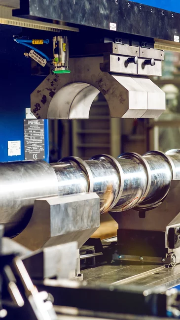 Foto: Gesco: Grosse blaue Maschinenanlage in der ein Metallrohr liegt